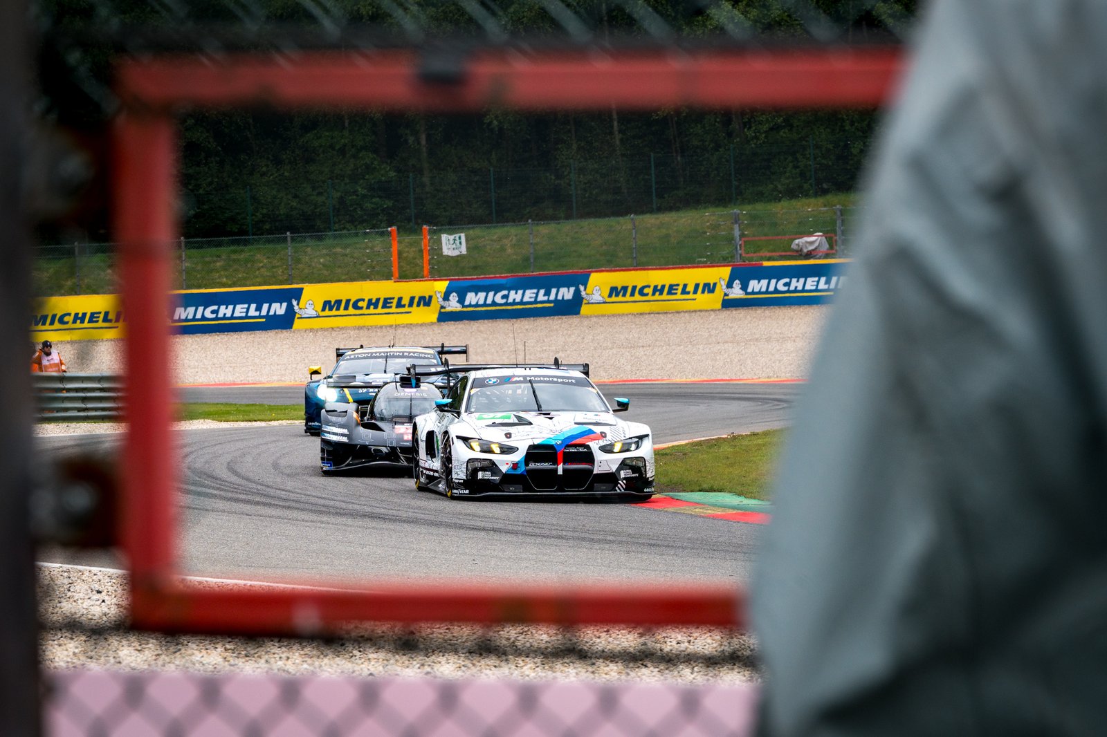 Shooting through a window to see BMW GT3 being chased by a Genesis hypercar