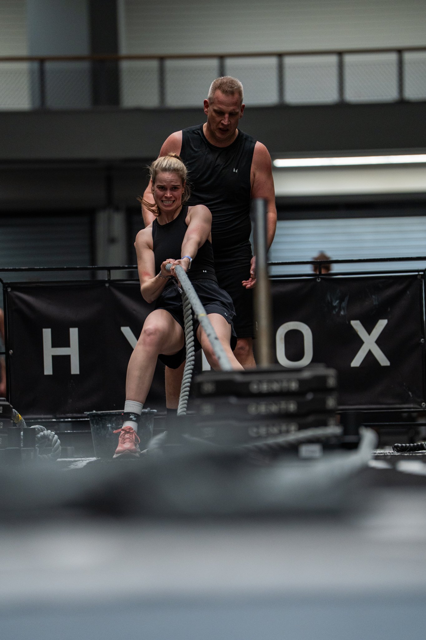 Woman pulling sled during Hyrox event