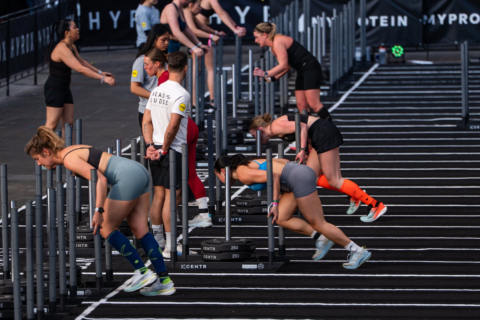 Women pushing sleds at Hyrox event
